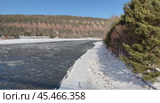 Video of Siberian river Irkut in November during freeze-up. Ice floes float on blue water. On shore is Shamanka village near famous Shamansky cliff, called 33 heroes bogatyrs - natural landmark. Стоковое видео, видеограф Виктория Катьянова / Фотобанк Лори