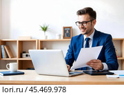 A businessman is working on a laptop in his office. Стоковое AI-изображение, AI-художник RamA / Фотобанк Лори