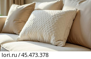 A cushion made of textured boucle fabric, against a background of other pillows. Стоковое AI-изображение, AI-художник Ольга Губская / Фотобанк Лори
