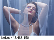 Portrait of a young female covered with veil. Woman is dressed in a peignoir and wears a necklace and earrings. Стоковое фото, фотограф Сергей Пристяжнюк (Serg Zastavkin) / Фотобанк Лори