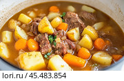 Delicious beef stew simmering with potatoes and carrots in pot. Стоковое AI-изображение, AI-художник Юрий Поздников / Фотобанк Лори