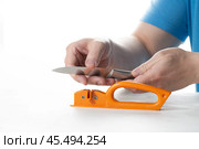 A knife sharpener. A man sharpens a knife on a special universal knife sharpener. Стоковое фото, фотограф Александр Поташев / Фотобанк Лори