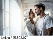 During a home renovation, a couple shares a lighthearted moment, smiling and looking into each other\'s eyes, covered in paint. Their connection shines through in the close-up. Стоковое AI-изображение, AI-художник Sergey Grishin / Фотобанк Лори