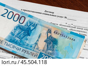 Договор о предоставлении социальных услуг и пачка денег. Стоковое фото, фотограф Игорь Низов / Фотобанк Лори