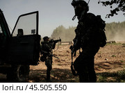 Пехотинцы ведут бой рядом с лесом. Силуэты российских военных рядом с автомобилем. Игроки в страйкбол сражаются с неприятелем, находясь в тени деревьев. (2018 год). Редакционное фото, фотограф Евгений Зимин / Фотобанк Лори