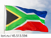 Against background of cloudy sky, South African flag flapping in wind on flagpole. Стоковое фото, фотограф Яков Филимонов / Фотобанк Лори