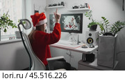 Female graphic designer in home studio uses AI for visual creativity. AI-powered tools optimize her workflow, creating artistic and innovative Christmas-themed designs. Стоковое видео, видеограф Енваев Андрей / Фотобанк Лори