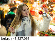 Portrait of dreamily happy girl with Christmas balls in her hands at a street fair in evening. Стоковое фото, фотограф Яков Филимонов / Фотобанк Лори