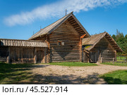View of an ancient log building on the territory of the Pushkin village in Bugrovo of the Pushkin Museum-Reserve on a sunny summer day, Pushkinskiye Gory, Pskov region, Russia. Редакционное фото, фотограф Ula Ulachka / Фотобанк Лори