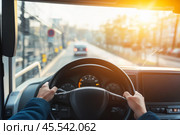 Driver turns steering wheel of truck, bus at sunset. POV. Skilled chauffeur drives lorry to deliver freight. Cargo shipping service. Journey. Drivers Hands on a wheel. Travel. Personal Perspective. Стоковое AI-изображение, AI-художник Марина Демидюк / Фотобанк Лори