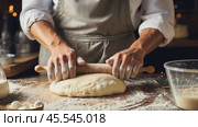 A person is rolling out dough on a wooden surface. Crafting bread, a baker works amidst baking essentials on a table. . Стоковое AI-видео, аниматор Igor Tichonow / Фотобанк Лори