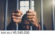 Person behind bars with sense of confinement and longing for freedom. Barrier to liberation. Prisoner young man in prison. Стоковое AI-видео, аниматор Igor Tichonow / Фотобанк Лори