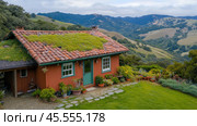 Charming cottage with a green roof nestled in rolling hills and lush greenery, AI. Стоковое AI-изображение, AI-художник Сергей Старуш / Фотобанк Лори
