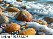 Берег моря или озера с крупными гладкими камнями, которые омываются водой. Стоковое AI-изображение, AI-художник Valeryi Vysotkov / Фотобанк Лори