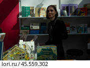 06.04.2023, Москва. Международная ярмарка интеллектуальной литературы «non/fictioNвесна» в Гостином дворе. Девушка-продавец книг. Редакционное фото, фотограф Дмитрий Киселёв / Фотобанк Лори