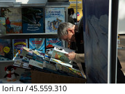 06.04.2023, Москва. Международная ярмарка интеллектуальной литературы «non/fictioNвесна» в Гостином дворе. Мужчина всматривается в книгу. Редакционное фото, фотограф Дмитрий Киселёв / Фотобанк Лори