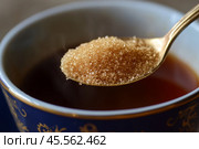 Person adding cane sugar with a spoon to cup of fresh aromatic coffee. Close up of teaspoon putting brown sugar into hot steamed drink mug. Sugar Being Poured into Cup of Coffee Americano, Close-Up. Стоковое AI-изображение, AI-художник Марина Демидюк / Фотобанк Лори