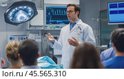 Surgeon explaining surgical procedure to team of interns in operating room. Стоковое AI-видео, аниматор Юрий Поздников / Фотобанк Лори