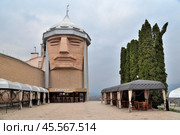 Nalchik, Kabardino-Balkarian Republic, Russia, March 24, 2023: Building of Sosruko restaurant in form of hero's head with torch on mountain peak Malaya Kizilovka of Northern Caucasus. Редакционное фото, фотограф Алексей Антипов / Фотобанк Лори