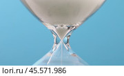 Hourglass close-up on a blue background, concept on the theme of the passage of time. Стоковое видео, видеограф Сергей Чайко / Фотобанк Лори