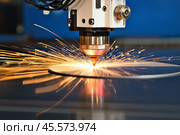 CNC Laser engraving in operation. Close-up of plasma laser machining of metal with sparks, modern industrial technology. Laser machinery cutting iron sheet with sparkling. Hi-technology manufacturing. Стоковое AI-изображение, AI-художник Марина Демидюк / Фотобанк Лори