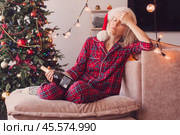 Sad lonely middle aged woman complaining in christmas sitting on couch. Стоковое фото, фотограф Гладских Татьяна / Фотобанк Лори