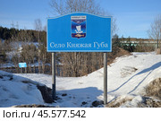 Knyazhaya Guba Village, urban settlement of Zelenoborsky, Kandalaksha district, Murmansk region, March 23, 2024: Banner Knyazhaya Guba village with coat of arms on bank of Knyazhegubskaya hydroelectric power station canal. Редакционное фото, фотограф Алексей Антипов / Фотобанк Лори