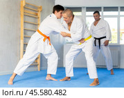 Aged man working on jiu-jitsu techniques in training fight with young rival. Стоковое фото, фотограф Яков Филимонов / Фотобанк Лори