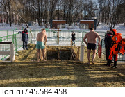 Люди купаются в проруби на праздник Крещения в Воронцовском парке, Москва (2022 год)./ Epiphany bathing in the ice hole in the Vorontsovo estate, Moscow. Редакционное фото, фотограф Iva Noel / Фотобанк Лори