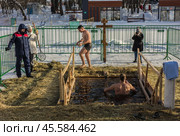 Люди купаются в проруби на праздник Крещения в Воронцовском парке, Москва (2022 год)./ Epiphany bathing in the ice hole in the Vorontsovo estate, Moscow. Редакционное фото, фотограф Iva Noel / Фотобанк Лори