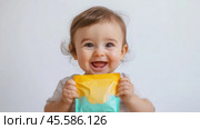 Adorable baby enjoying healthy snack with squeezable food pouch. Стоковое AI-изображение, AI-художник Sabyna75 / Фотобанк Лори