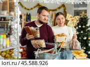 Man and a woman choose sweets for Christmas. Стоковое фото, фотограф Яков Филимонов / Фотобанк Лори