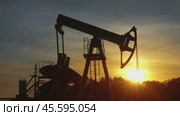 Working oil pump silhouette against sunset. Стоковое видео, видеограф Михаил Коханчиков / Фотобанк Лори