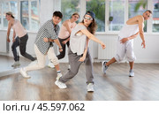 Young girl standing performs basic hip hop movements in front of group of students. Стоковое фото, фотограф Яков Филимонов / Фотобанк Лори