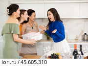 Three women have arrived for birthday celebration and presenting gift to birthday woman. Стоковое фото, фотограф Яков Филимонов / Фотобанк Лори