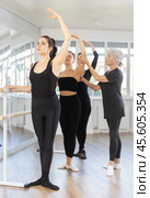 Women maintaining third ballet position at rehearsal with female instructor. Стоковое фото, фотограф Яков Филимонов / Фотобанк Лори