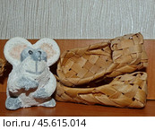 Лапти из липового лыка, рядом симпатичный глиняный мышонок. Натюрморт. Стоковое фото, фотограф Сергей Елизарьев / Фотобанк Лори