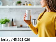 The girl advertises Biologically active additives, medicines. A white jar is in the young woman's hand. Стоковое AI-изображение, AI-художник Ирина Ручушкина / Фотобанк Лори