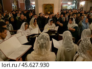 07.01.2023. Раменское, Троицкий собор. Хористы под руководством женщины-дирижёра поют во время Рождественской службы. Редакционное фото, фотограф Дмитрий Киселёв / Фотобанк Лори
