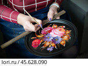 Жостово. Художник рисует цветы на подносе на Жостовской фабрике декоративной росписи. (2023 год). Редакционное фото, фотограф Дмитрий Киселёв / Фотобанк Лори