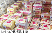 Moscow December 04, 2024, Butter in packaging on a store counter. Concept of increasing prices for butter. Refrigerator in a grocery store with briquettes of natural butter. Редакционное фото, фотограф Скрипачев Антон / Фотобанк Лори