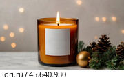 A mock-up of a cozy burning candle made of amber glass with an empty white label in a festive, New Year's home interior. Стоковое AI-изображение, AI-художник Photojuli / Фотобанк Лори