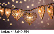 The concept of Valentine's Day, a banner with garlands in the form of hearts and magic lights for a holiday filled with love. A place for the text. Стоковое AI-изображение, AI-художник Photojuli / Фотобанк Лори