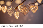 The concept of Valentine's Day, a banner with garlands in the form of hearts and magic lights for a holiday filled with love. A place for the text. Стоковое AI-изображение, AI-художник Photojuli / Фотобанк Лори