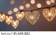The concept of Valentine's Day, a banner with garlands in the form of hearts and magic lights for a holiday filled with love. A place for the text. Стоковое AI-изображение, AI-художник Photojuli / Фотобанк Лори