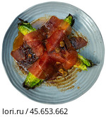Cores of garden green salad are laid out on plate, baked with slices of fatty pork bacon. Стоковое фото, фотограф Яков Филимонов / Фотобанк Лори