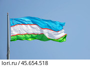 Государственный флаг Узбекистана на фоне голубого неба (2022 год). Стоковое фото, фотограф Анна Карасева / Фотобанк Лори
