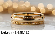 Gold wedding rings on a white background with a side. Wedding rings. The wedding day. The newlyweds. Стоковое AI-изображение, AI-художник Photojuli / Фотобанк Лори
