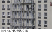 ANGARSK, IRKUTSK REGION, RUSSIA - October 08, 2024: Video of builders work on a high-rise modern residential building and glazing balconies. Housing construction concept. Редакционное видео, видеограф Виктория Катьянова / Фотобанк Лори
