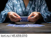 Cards in the hands of a fortune teller, fortune telling. Стоковое AI-изображение, AI-художник Евгений Харитонов / Фотобанк Лори